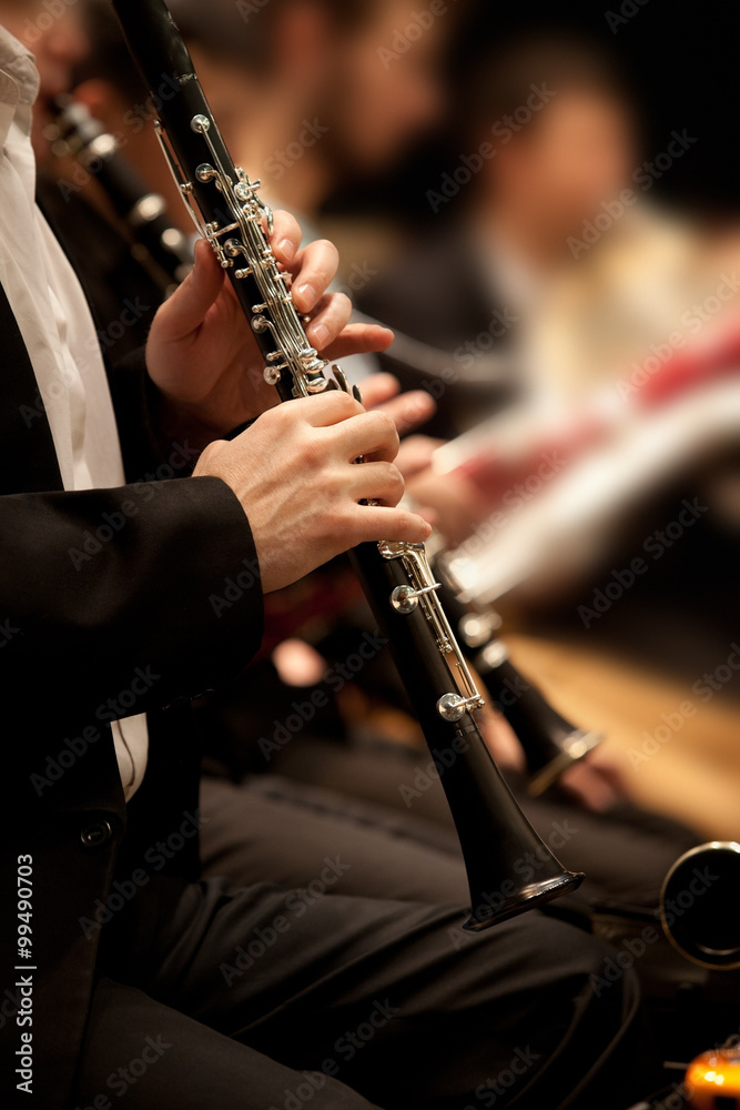 Fototapeta premium Hands of man playing the clarinet in the orchestra in dark colors