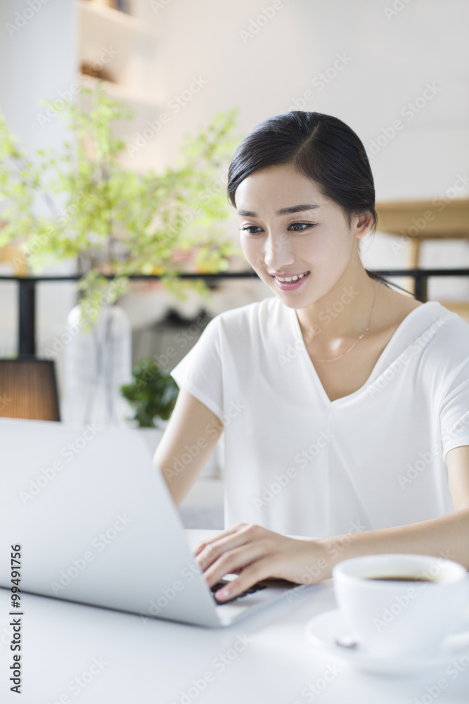 Happy young woman using laptop in coffee shop Happy young woman using laptop in coffee shop