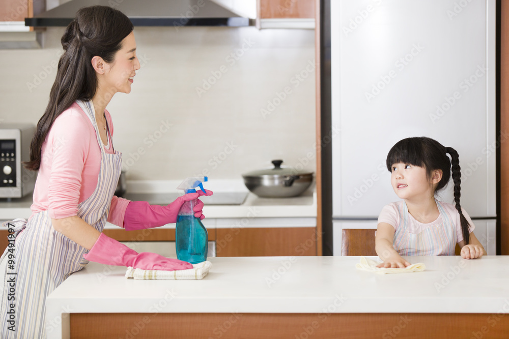 Mother and daughter cleaning kitchen counter Mother and daughter cleaning kitchen counter