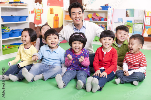 Male teacher with cute kindergarten children