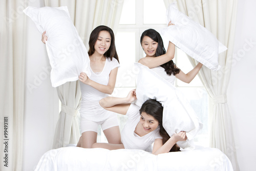 Best female friends playing pillow fights at home