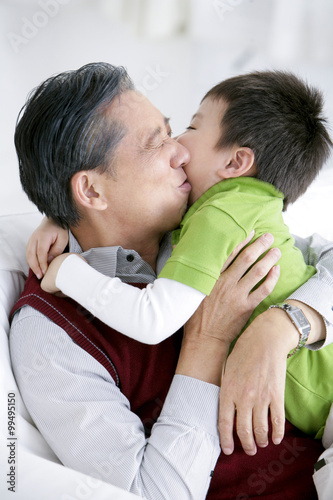 Chinese grandfather kissing grandson