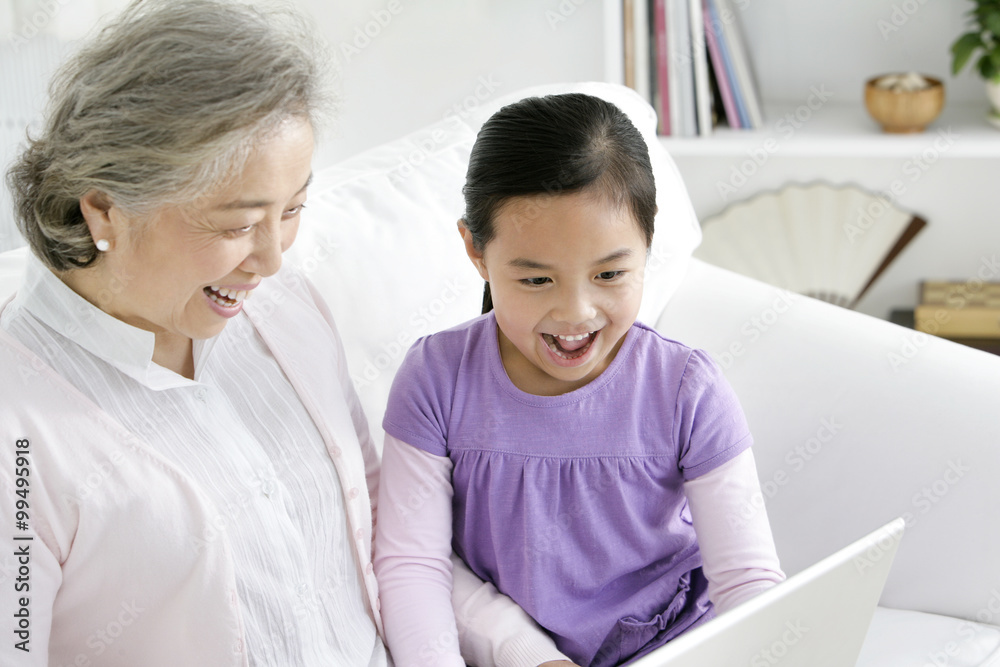 Chinese grandmother with grandaughter using a laptop Chinese grandmother with grandaughter using a laptop