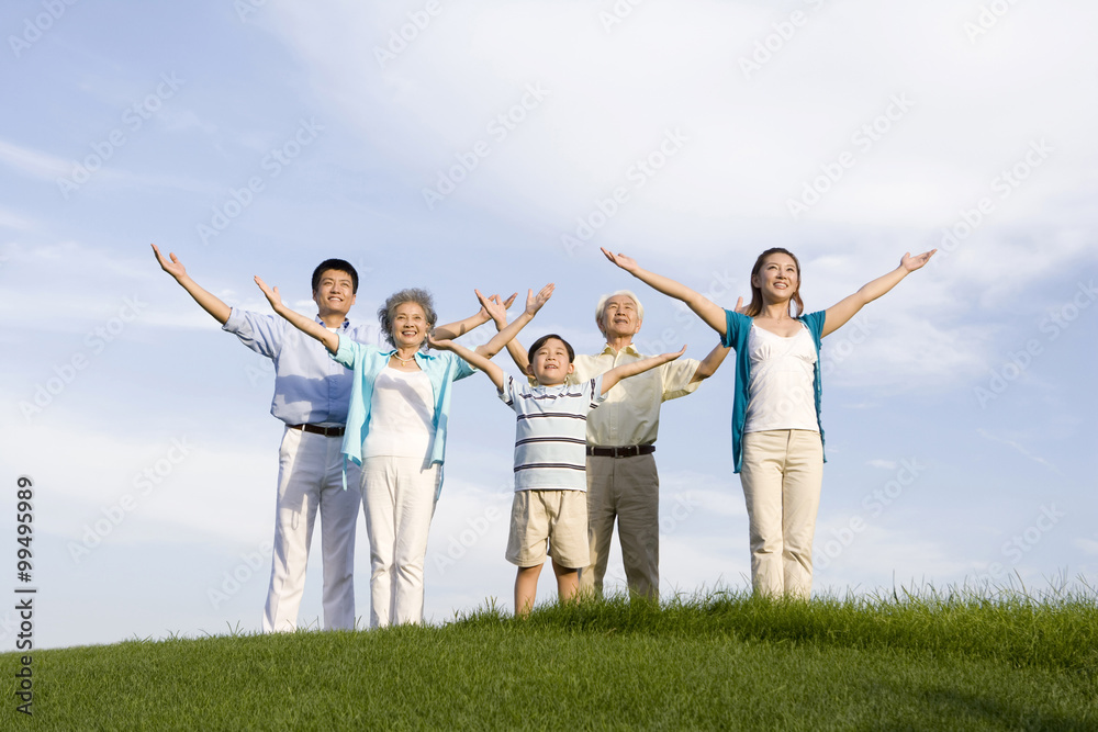 Family standing on the grass, arms outstretched Family standing on the grass, arms outstretched