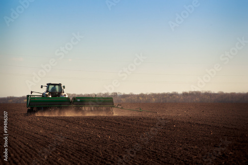 panorama of tractor sowing in field