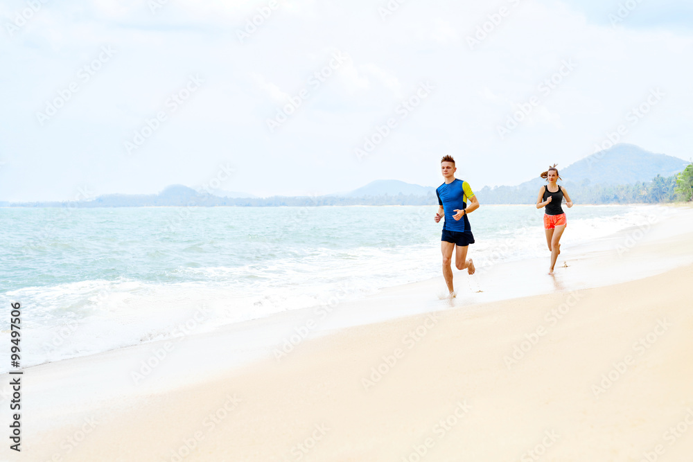 Healthy Lifestyle. Athletic Runner Couple Running On Beach, Training For Marathon. Sporty Fit People Jogging Near Sea ( Ocean ) During Outdoor Workout. Sports And Fitness. Exercising. Health Concept