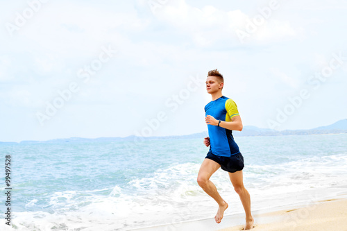 Wellness. Fit Athletic Man Running On Beach, Training For Marathon. Sporty Male Runner Jogging During Outdoor Workout In Morning. Sports, Run, Fitness And Exercising. Healthy Lifestyle, Health Concept © puhhha