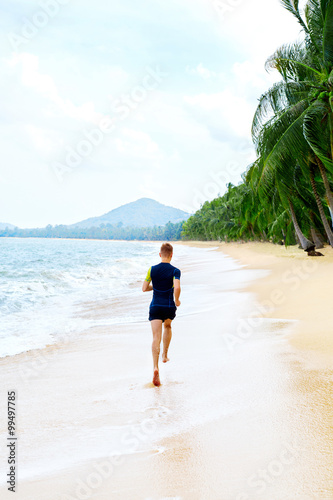 Run. Fit Athletic Man Running On Beach, Male Athlete Runner Jogging On Wet Sand During Outdoor Workout. Athletics. Sports, Fitness And Exercising. Healthy Lifestyle, Wellness And Health Concept