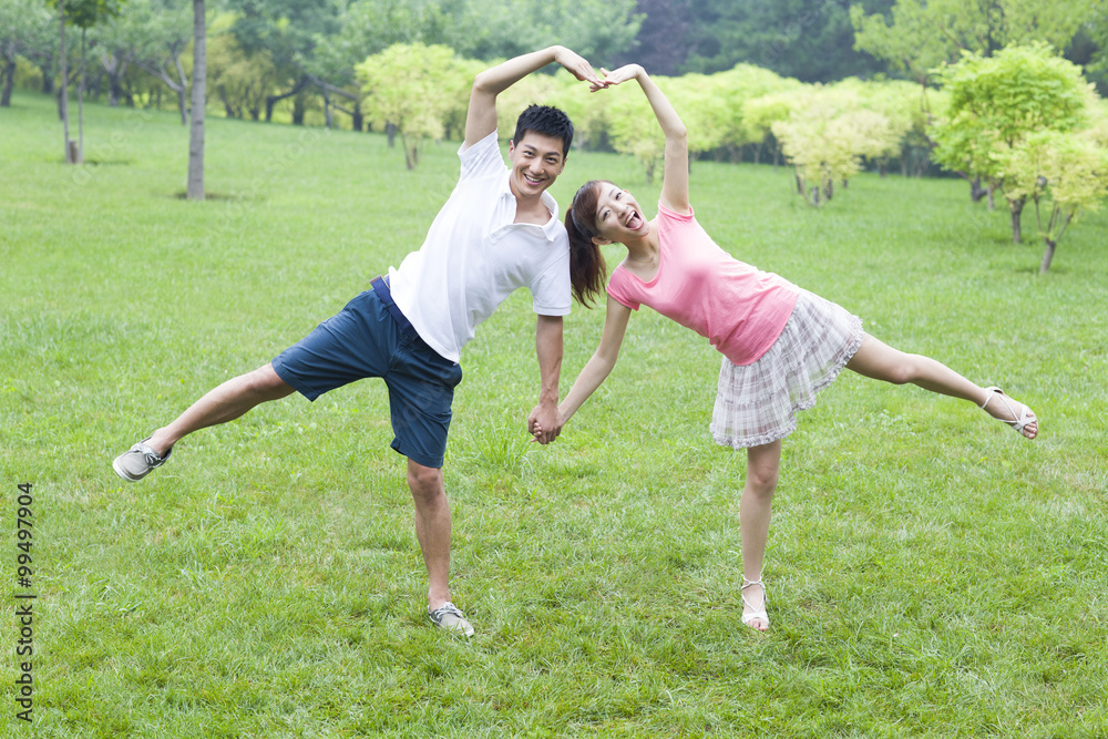 Sweet young couple making heart shape with arms Sweet young couple making heart shape with arms