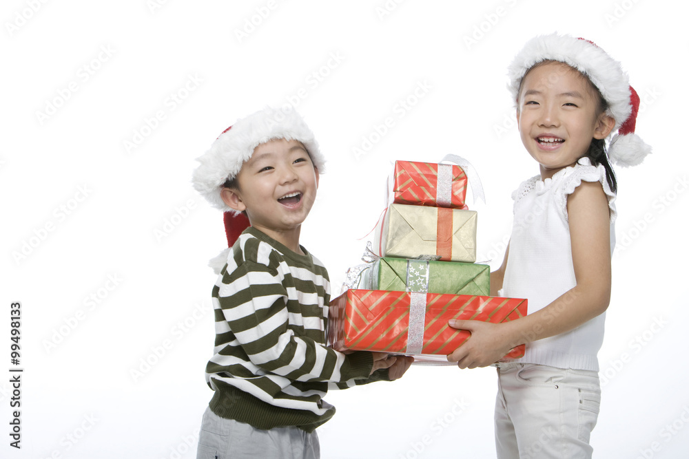 Boy and girl with Santa hats holding gift box Boy and girl with Santa hats holding gift box
