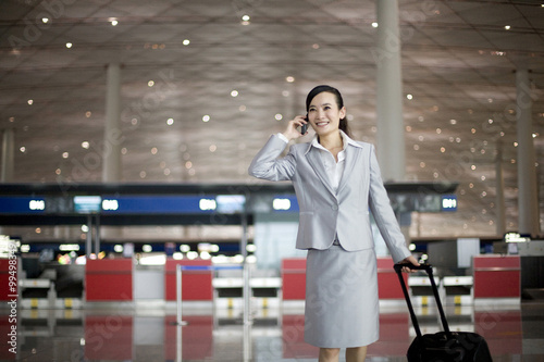 Businesswoman using cellphone in airport