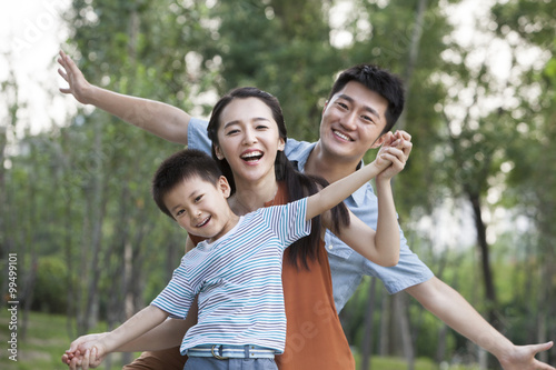 Portrait of happy young family with arms outstretched