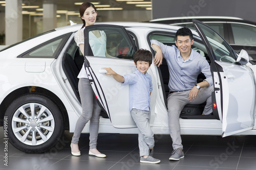 Young family choosing car in showroom