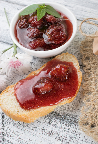 Canned strawberry confiture and jam sandwich on the wooden board