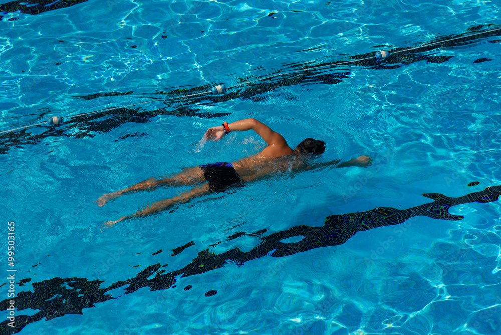man swimming in a blue swimming pool