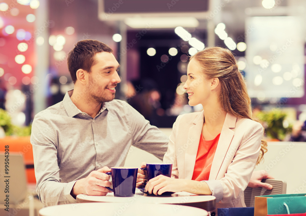 happy couple with shopping bags drinking coffee