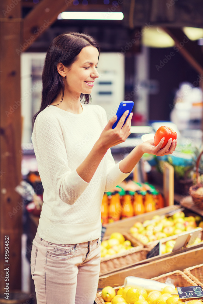 happy woman with smartphone and tomato in market happy woman with smartphone and tomato in market