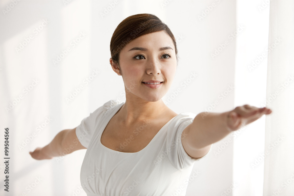 Young woman practicing yoga with arms outstretched Young woman practicing yoga with arms outstretched