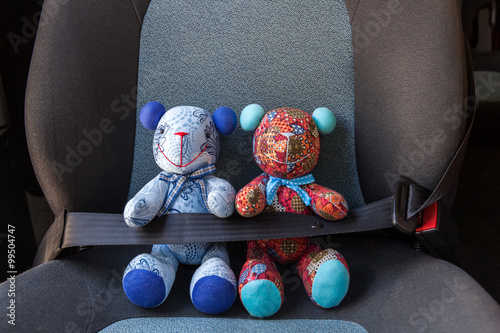 Stuffed toys buckled with safety belt in a car
