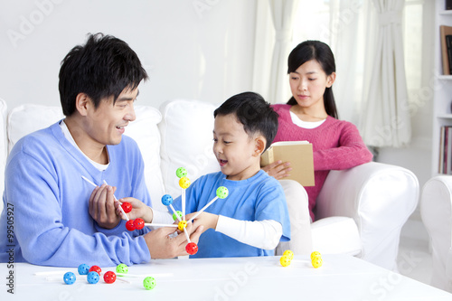 Young Chinese boy with parents and toys in the living room