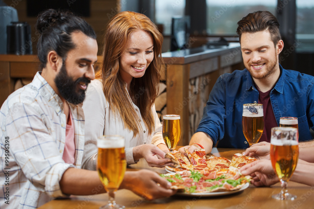 friends eating pizza with beer at restaurant
