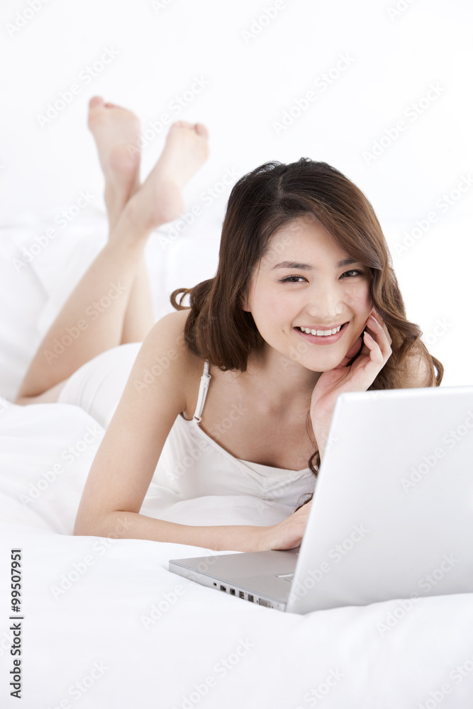 Young woman using laptop in bed Young woman using laptop in bed