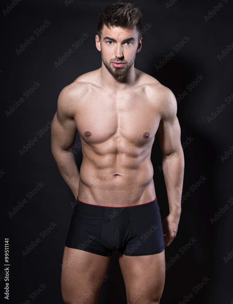 handsome young bodybuilder with toned body posing shirtless