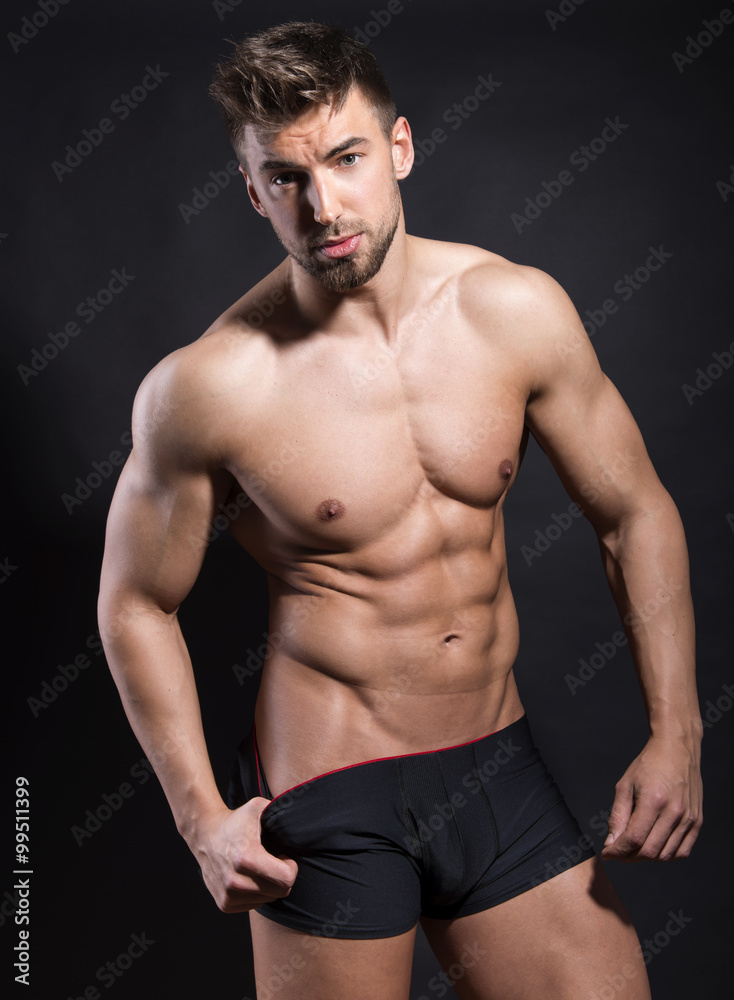 Fototapeta premium handsome young bodybuilder with toned body posing shirtless