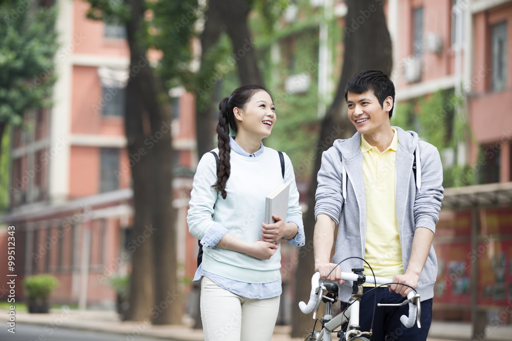 Fototapeta premium Young couple walking on campus