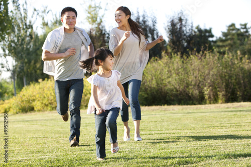 Young family running in a field