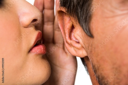 Woman whispering in man ear photo