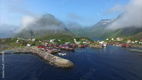 Low flight above fishing village A i Lofoten in Norway, popular tourist destination famous for natural beauty and typical red rorbu cabins. Aerial 4k Ultra HD.