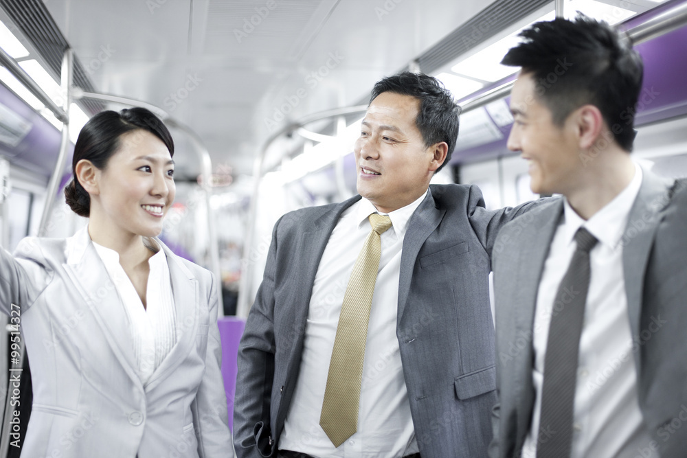 Smiling business people traveling in subway train Smiling business people traveling in subway train