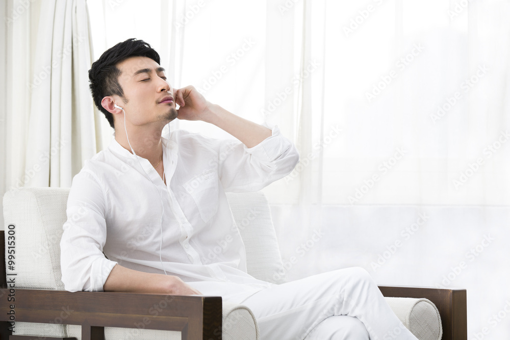 Young man enjoying music in sofa Young man enjoying music in sofa