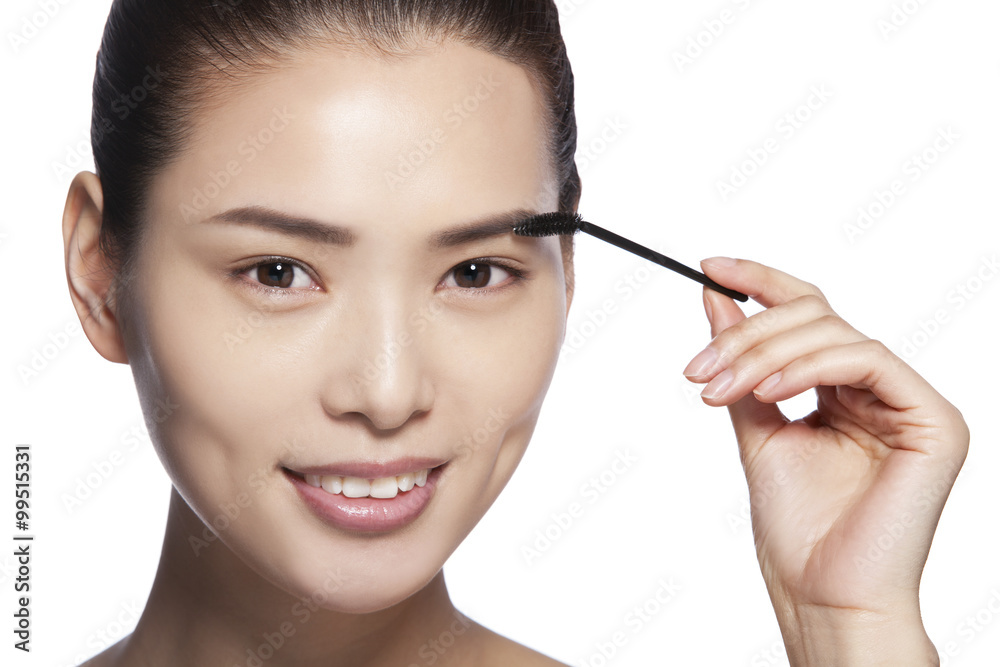 Headshot of young woman applying makeup Headshot of young woman applying makeup