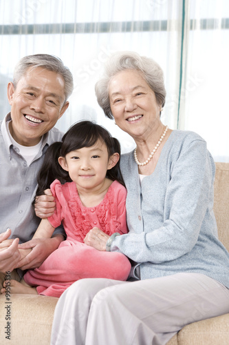 Elderly couple with granddaughter on couch