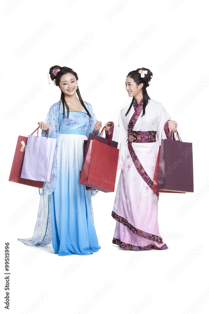 Happy young women in traditional Chinese costume with shopping bags
