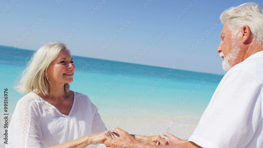 Dancing romantic senior Caucasian couple sharing a kiss on a beach Dancing romantic senior Caucasian couple sharing a kiss on a beach