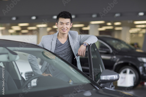 Young man buying car in showroom © Blue Jean Images