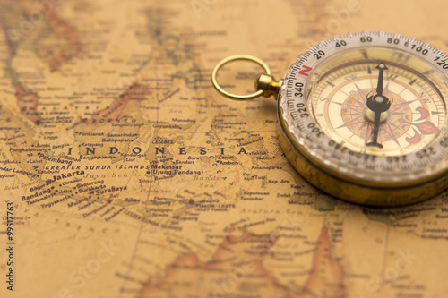 Photo Old compass on vintage map selective focus on Indonesia