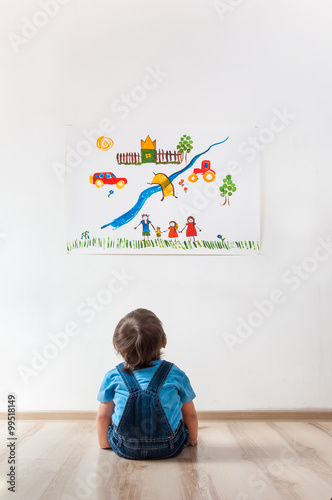 child looking at the picture on the wall
