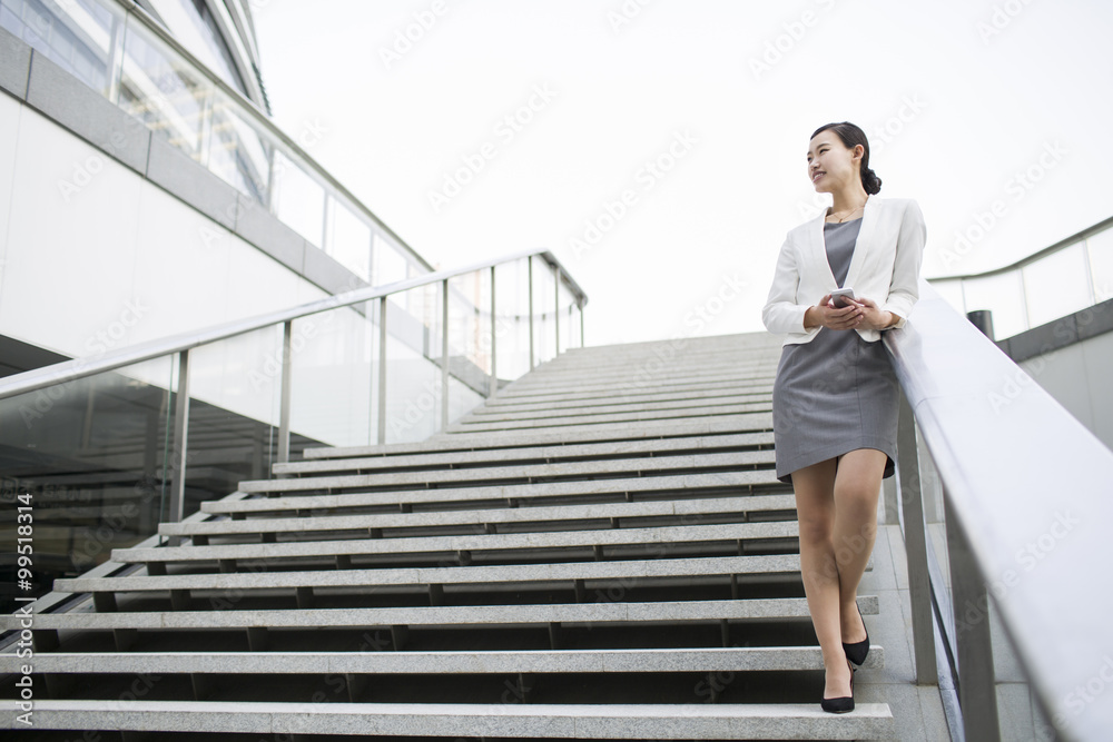 Businesswoman standing on the stairs