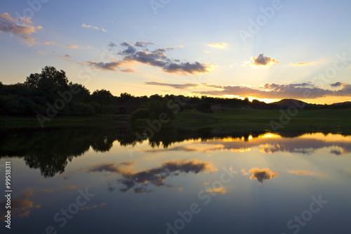 Sun rising over a small lake © Blue Jean Images