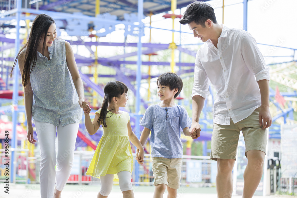 Fototapeta premium Happy young family playing in amusement park