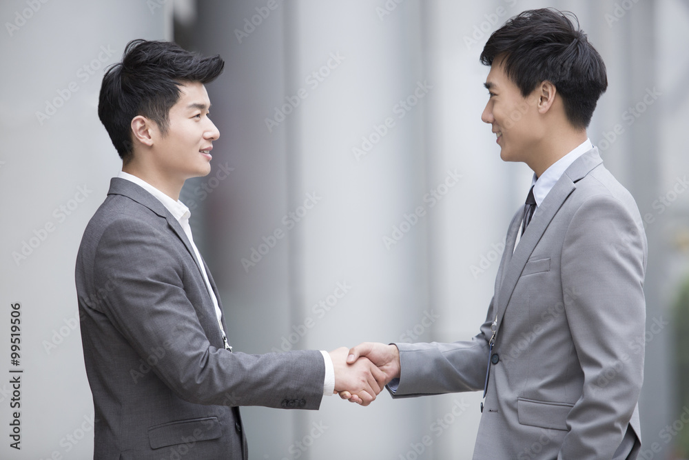 Young business person shaking hands outdoors Young business person shaking hands outdoors