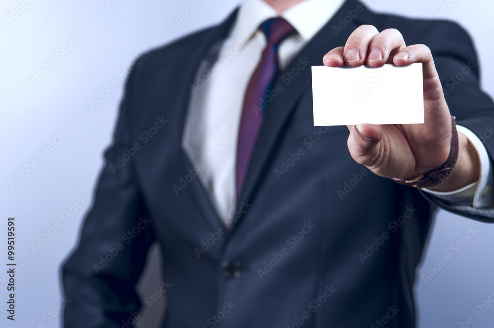Man in dark suit holds business card Man in dark suit holds business card
