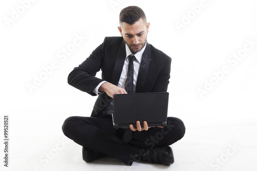 Portrait of young businessman with laptop isolated on white back © Marino Bocelli