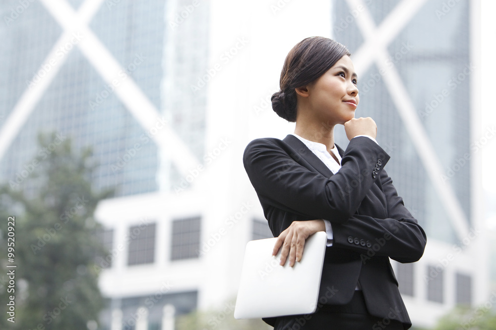 Cheerful businesswoman hand on chin with digital tablet in hand, Hong Kong Cheerful businesswoman hand on chin with digital tablet in hand, Hong Kong