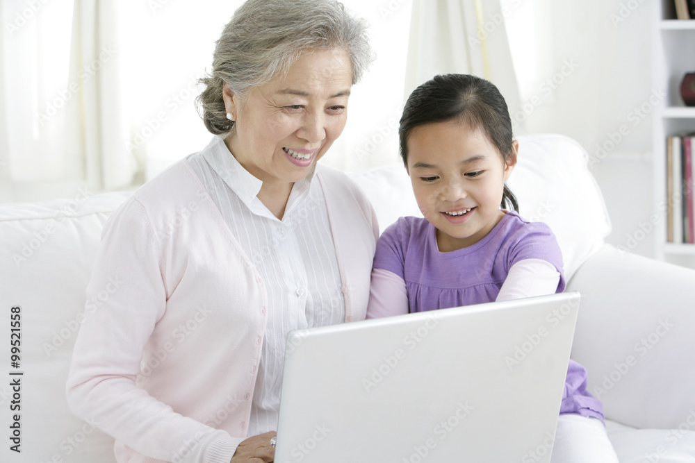 Chinese grandmother with grandaughter using a laptop Chinese grandmother with grandaughter using a laptop