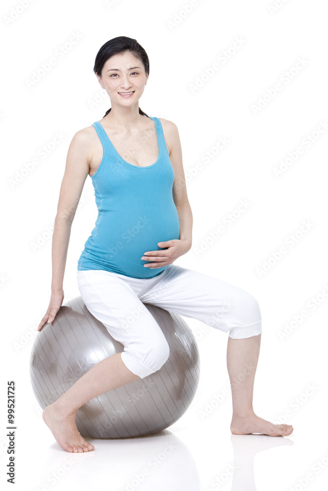 Young pregnant woman sitting on fitness ball Young pregnant woman sitting on fitness ball